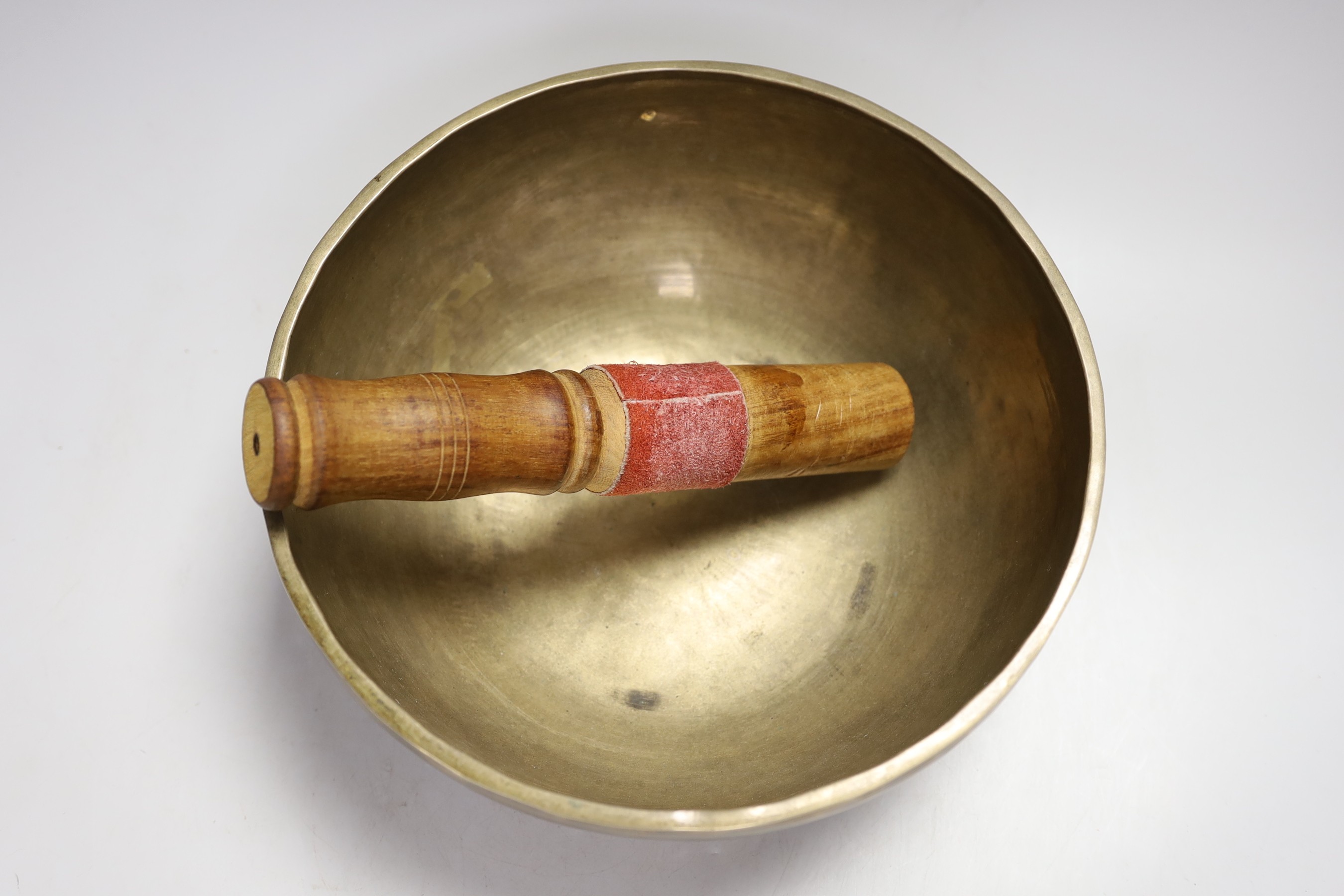 A plated figure of Ganesha and a Tibetan singing bowl with striker
